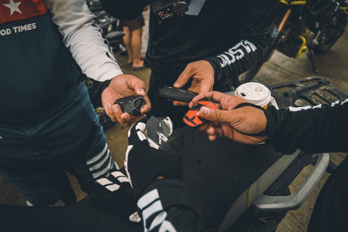 Riders holding their RESO communication devices together