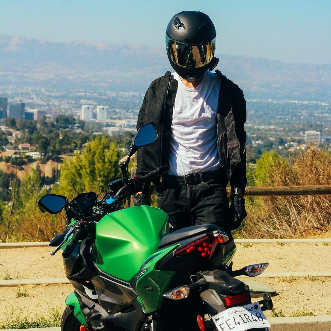 Rider standing by a green sport bike
