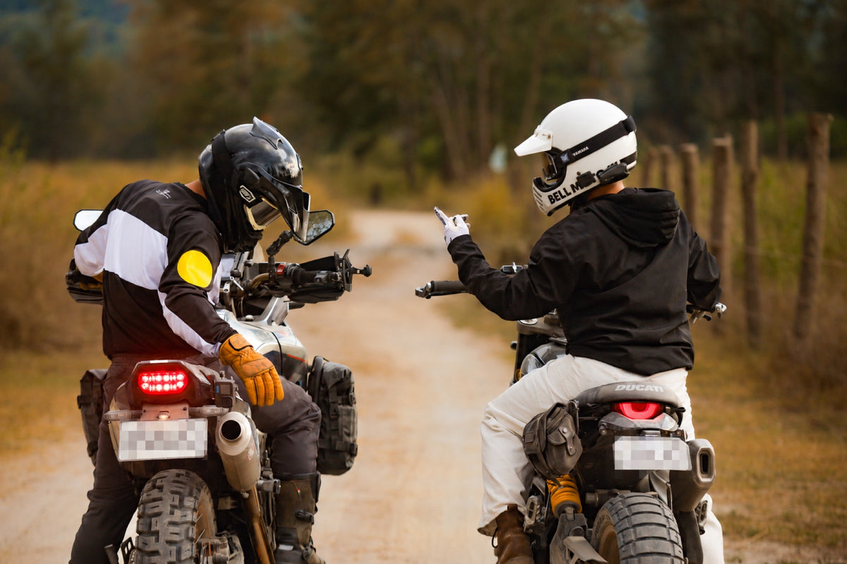 Two riders sharing a moment, with both license plates redacted